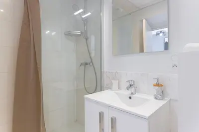 a white bathroom with a sink and a shower at LE MIMONT studio central et calme, séjours en couple ou congrès in Cannes
