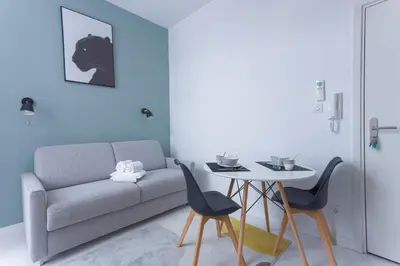a living room with a couch and a table at LE MIMONT studio central et calme, séjours en couple ou congrès in Cannes