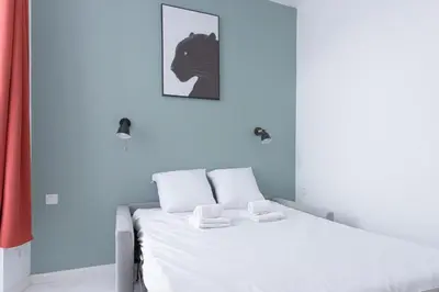 a bedroom with a bed with a picture of a horse on the wall at LE MIMONT studio central et calme, séjours en couple ou congrès in Cannes