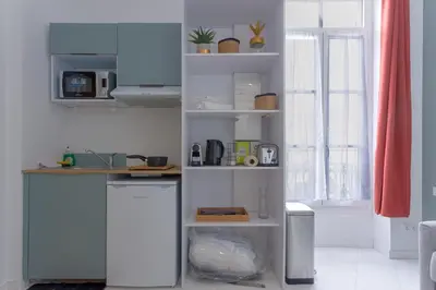 a kitchen with white cabinets and a counter top at LE MIMONT studio central et calme, séjours en couple ou congrès in Cannes