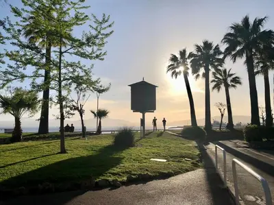 a couple of people walking down a path with palm trees at Studio bord de mer, Croisette, Cannes in Cannes