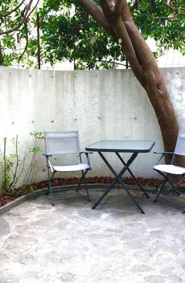 a table and two chairs sitting next to a tree at Studio bord de mer, Croisette, Cannes in Cannes