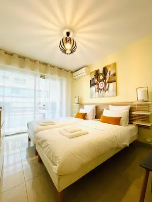 a large bed in a room with a large window at Bel appartement Centre ville, mer, Croisette in Cannes