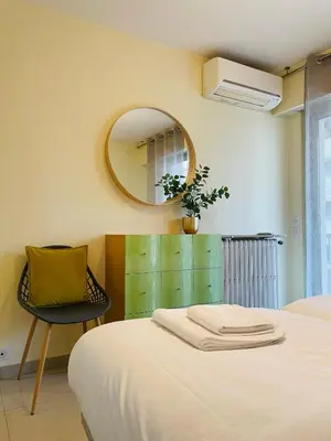a bedroom with a bed and a mirror and a chair at Bel appartement Centre ville, mer, Croisette in Cannes