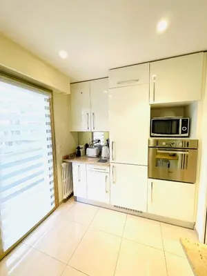 a kitchen with white cabinets and a microwave at Bel appartement Centre ville, mer, Croisette in Cannes