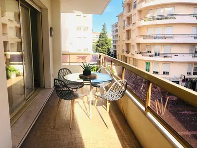 a balcony with a table and chairs and a building at Bel appartement Centre ville, mer, Croisette in Cannes