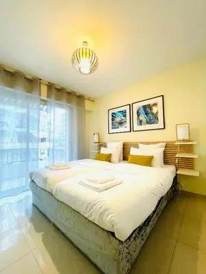 a large bed in a room with a large window at Bel appartement Centre ville, mer, Croisette in Cannes