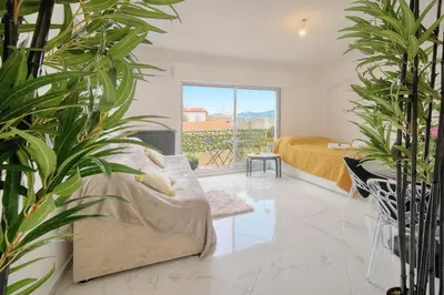 a living room with a couch and plants at Lumineux Studio TERRASSE, Clémenceau-CANNES CENTRE A0B192 in Cannes