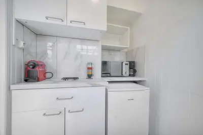 a kitchen with white cabinets and a red appliance at Lumineux Studio TERRASSE, Clémenceau-CANNES CENTRE A0B192 in Cannes