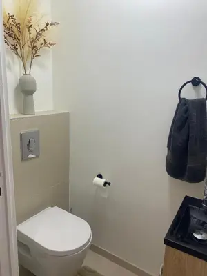 a bathroom with a toilet and a black bag on the wall at Elegant apartment close to Croisette and Palais de Festival with garage in Cannes