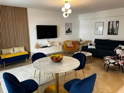 a living room with a table and blue chairs at Elegant apartment close to Croisette and Palais de Festival with garage in Cannes
