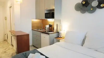 a bedroom with a bed and a small kitchen at Proche Croisette, Studio moderne by Palmazur Vacances in Cannes