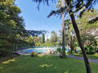 a yard with a swimming pool and trees at 2 bedrooms seafront in Cannes