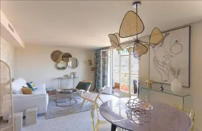 a living room with a table and a couch at LE ROCHER avec terrasse et vue mer, près du centre-ville in Cannes