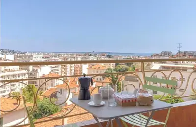 a table with a coffee maker on top of a balcony at LE ROCHER avec terrasse et vue mer, près du centre-ville in Cannes