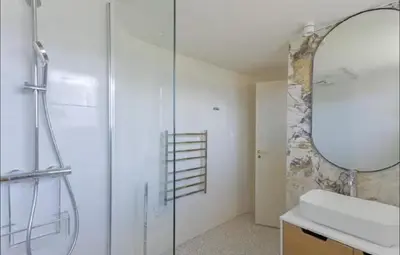 a bathroom with a shower and a sink and a mirror at LE ROCHER avec terrasse et vue mer, près du centre-ville in Cannes