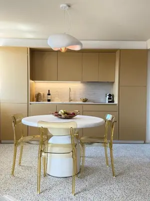 a kitchen with a white table and chairs in a room at LE ROCHER avec terrasse et vue mer, près du centre-ville in Cannes