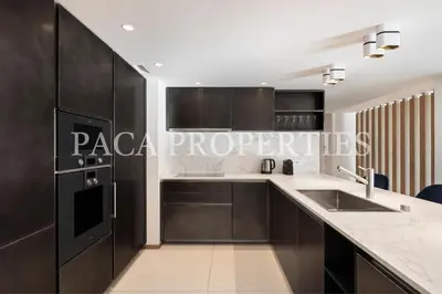 a kitchen with black and white cabinets and a sink at Paca Properties -401- 5 Chambres Luxe in Cannes