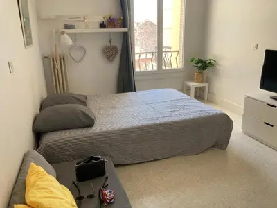 a bedroom with two beds and a television at Studio à 10 min de la croisette et de la mer et 5 min de la gare in Cannes