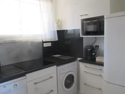 a kitchen with a washing machine and a microwave at Studio à 10 min de la croisette et de la mer et 5 min de la gare in Cannes