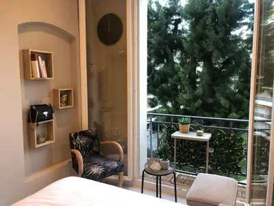 a bedroom with a bed and a window with a tree at Boulevard de la croisette PALAIS MIRAMAR in Cannes