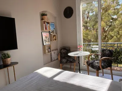 a bedroom with a bed and a table and chairs at Boulevard de la croisette PALAIS MIRAMAR in Cannes