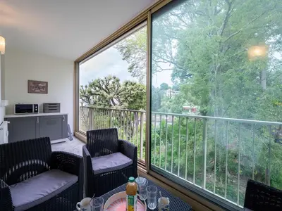 a balcony with two chairs and a large window at Apartment Val Joli-1 by Interhome in Cannes