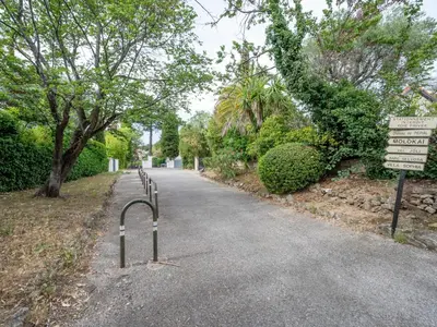 a road with a sign in the middle of a park at Apartment Val Joli-1 by Interhome in Cannes