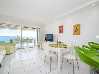 a white living room with a white table and chairs at Apartment Cannes Bay-3 by Interhome in Cannes