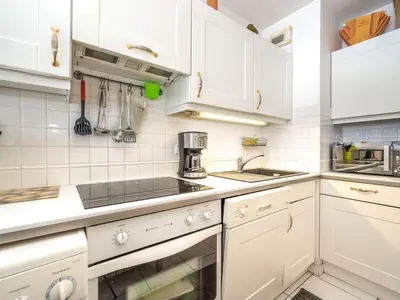 a white kitchen with white cabinets and a sink at Apartment Cannes Bay-3 by Interhome in Cannes