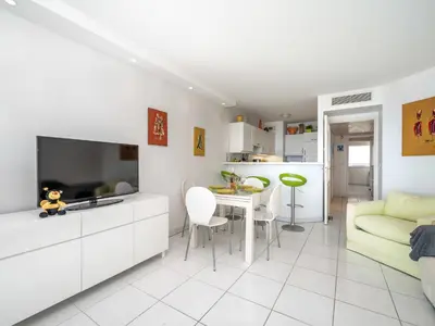 a living room with a tv and a couch and a table at Apartment Cannes Bay-3 by Interhome in Cannes
