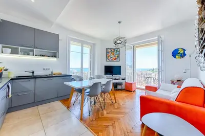 a kitchen and living room with a couch and a table at LE SINATRA splendide vue mer panoramique et balcon, idéal pour des séjours de loisirs ou business in Cannes