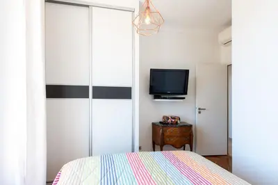 a bedroom with a bed and a tv on a wall at LE SINATRA splendide vue mer panoramique et balcon, idéal pour des séjours de loisirs ou business in Cannes