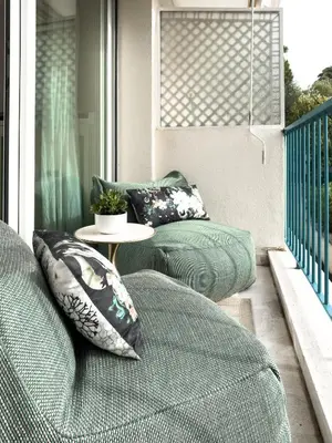 a porch with two beds and a table on a balcony at Cosy stay - LA CROISETTE in Cannes