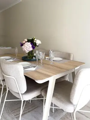 a wooden table with chairs and a vase of flowers at Cosy stay - LA CROISETTE in Cannes