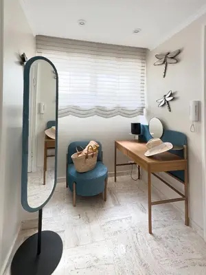 a mirror in a room with a blue chair and a table at Cosy stay - LA CROISETTE in Cannes