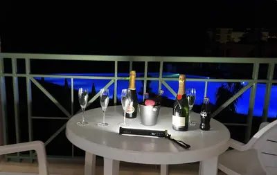 a white table with wine bottles and glasses on it at EXCEPTIONNEL sur CANNES vue mer piscine in Cannes