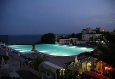 a large swimming pool lit up at night at EXCEPTIONNEL sur CANNES vue mer piscine in Cannes