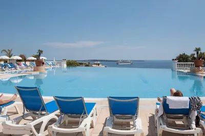 a pool at the resort with people sitting in lawn chairs at EXCEPTIONNEL sur CANNES vue mer piscine in Cannes