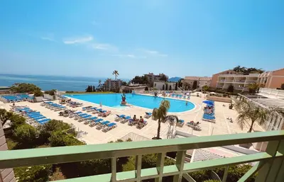 a view of a pool with lounge chairs and the ocean at EXCEPTIONNEL sur CANNES vue mer piscine in Cannes