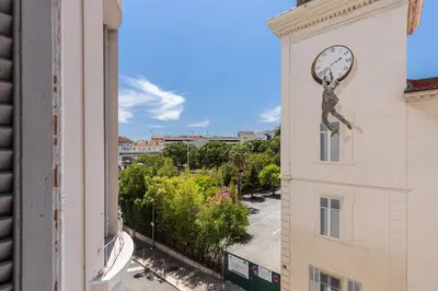 a clock on the side of a building at WABISABI SUITES - BRAILLE in Cannes