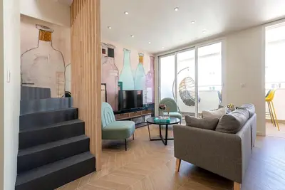 a living room with a staircase and a couch and a tv at Renovated bijou gem in heart of Cannes in Cannes