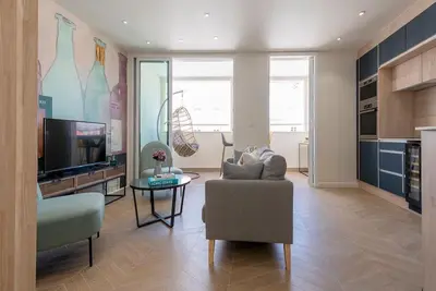 a living room with a couch and a television at Renovated bijou gem in heart of Cannes in Cannes