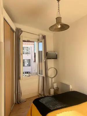 a living room with a couch and a kitchen at Joli 2 pièces au coeur de Cannes ! in Cannes