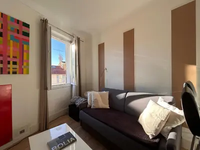 a large kitchen with a counter and chairs in it at Joli 2 pièces au coeur de Cannes ! in Cannes