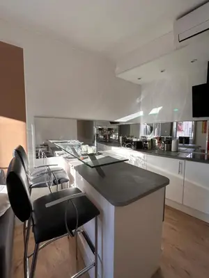 a living room with a couch and a table and a kitchen at Joli 2 pièces au coeur de Cannes ! in Cannes