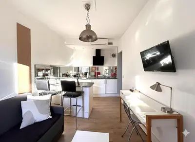 a living room with a couch and a table at Joli 2 pièces au coeur de Cannes ! in Cannes