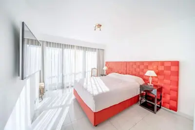 a bedroom with a large bed with a red headboard at PACA Properties 7C2 - appartement 3 chambres in Cannes