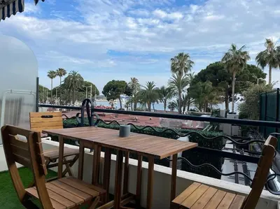 a table and chairs on a balcony with a view of the water at Cannes: Croisette Quartier Martinez - 90m² in Cannes