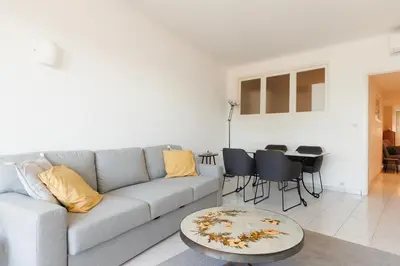 a living room with a couch and a table at Cannes: Croisette Quartier Martinez - 90m² in Cannes